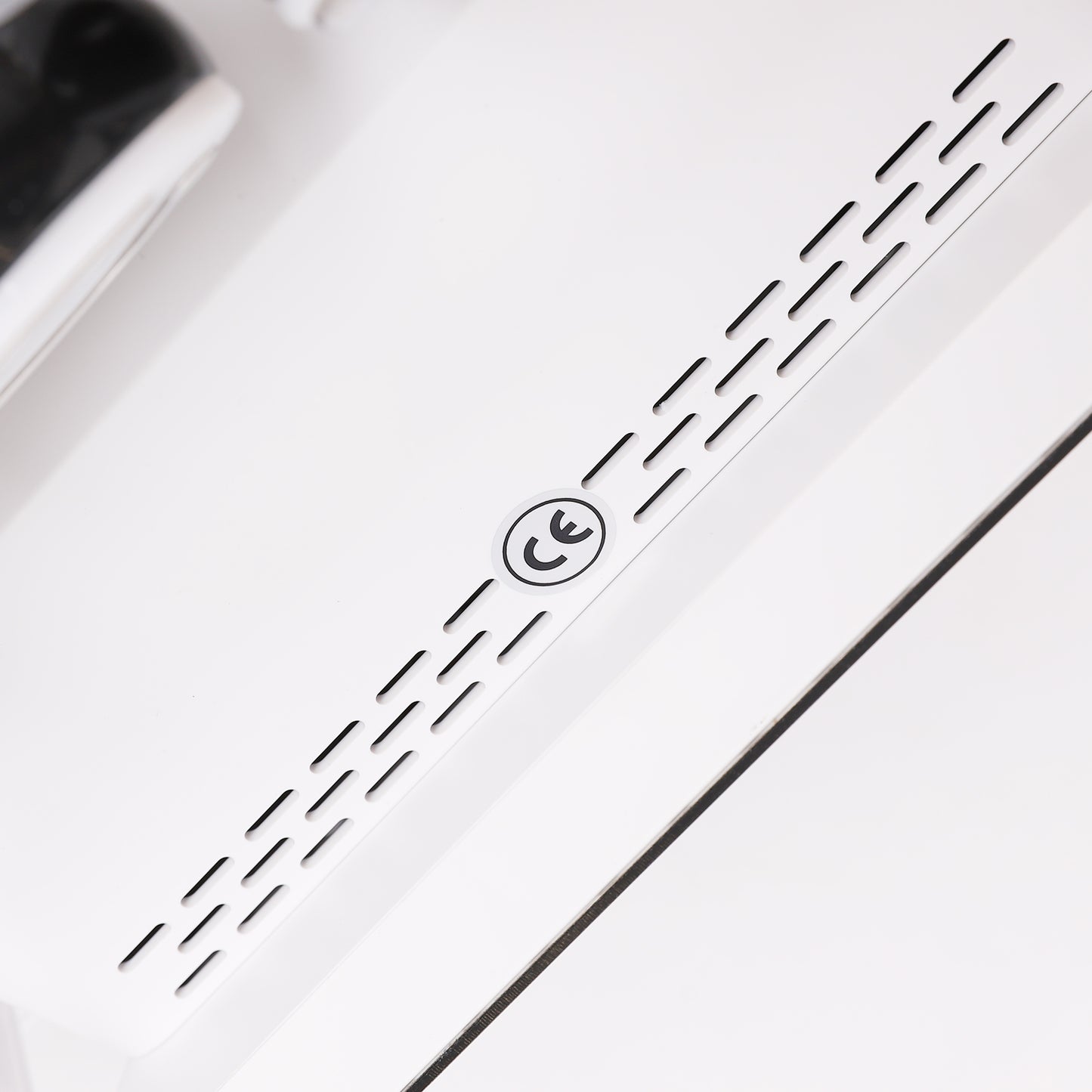 Close-up of a white electronic device with black text stating CE