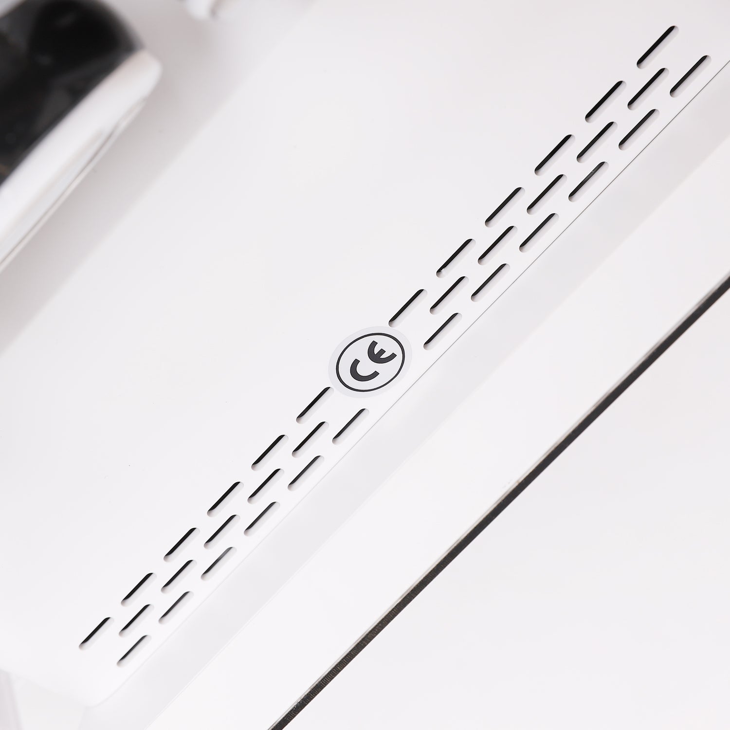 Close-up of a white electronic device with black text stating CE