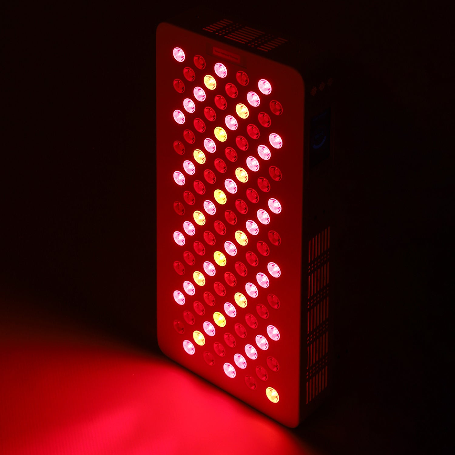 Therapy panel glowing red and infrared LEDs during active treatment mode.