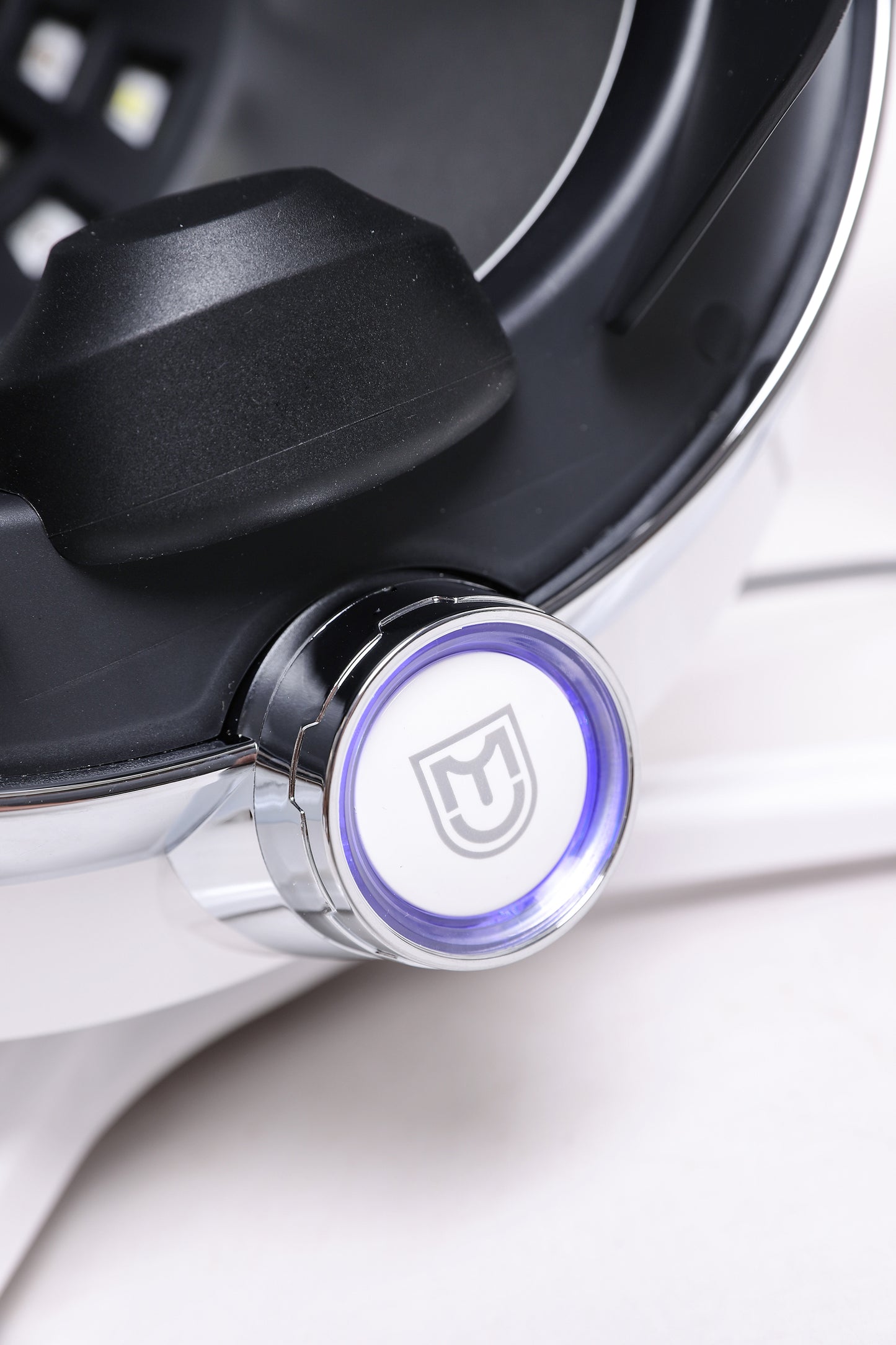 Detail view of AI skin scanner power button with illuminated design and modern aesthetic