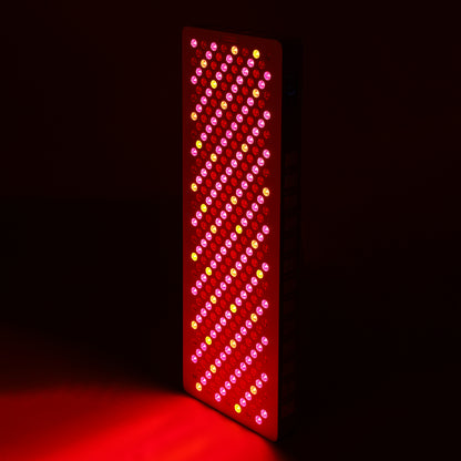 Panel fully lit in dark room, emitting intense red and near-infrared LED light.
