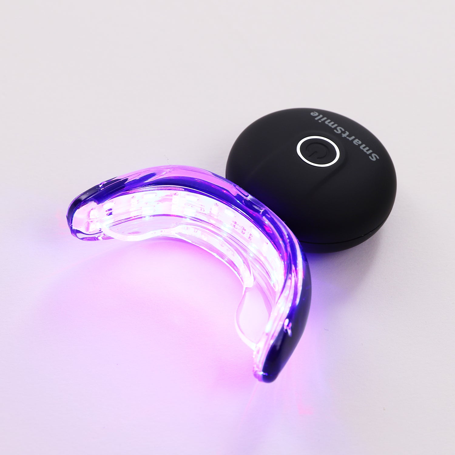 Activated SmartSmile LED tray glowing with whitening technology.
