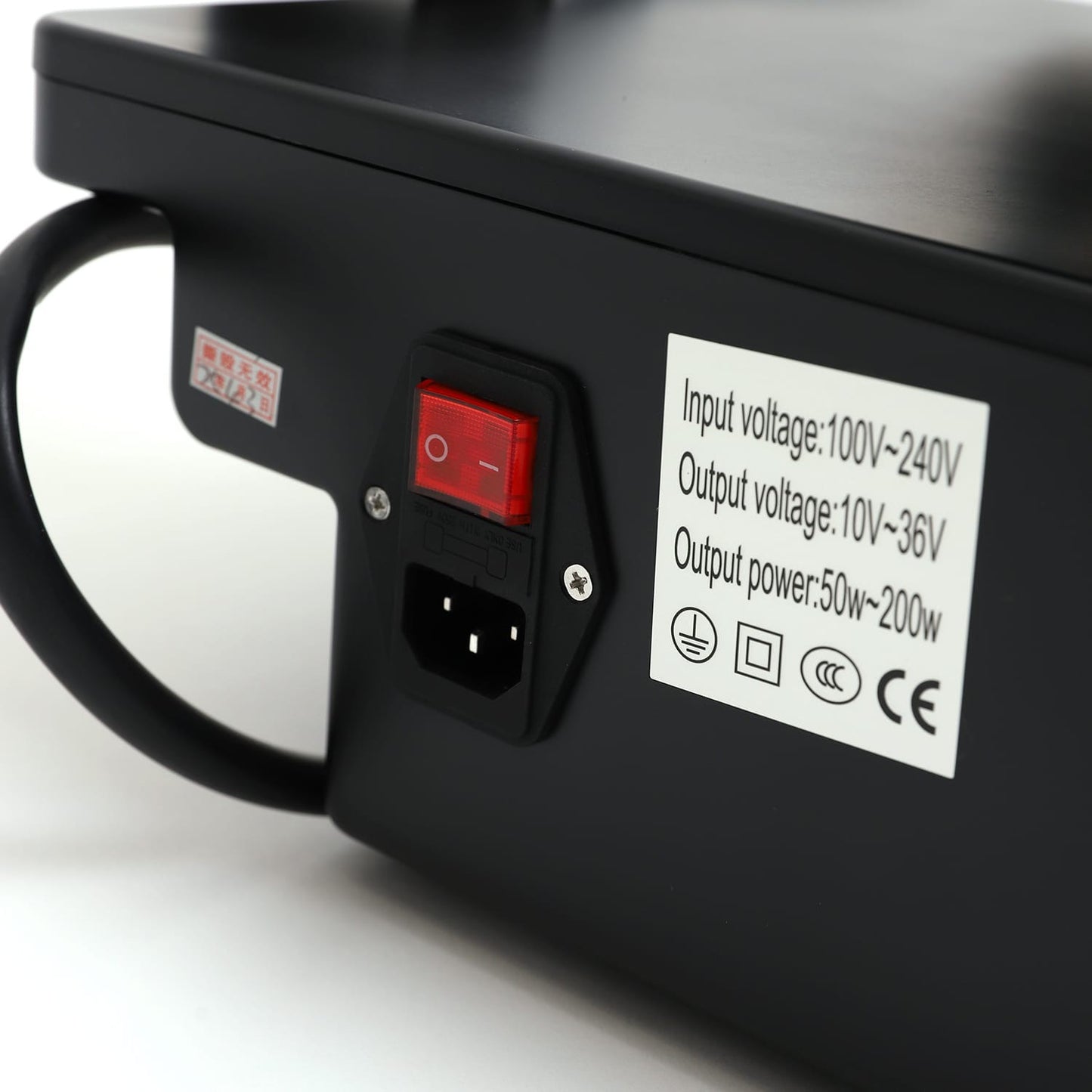 Close-up of RF microneedling device power switch and label showing input/output voltage and power specifications.