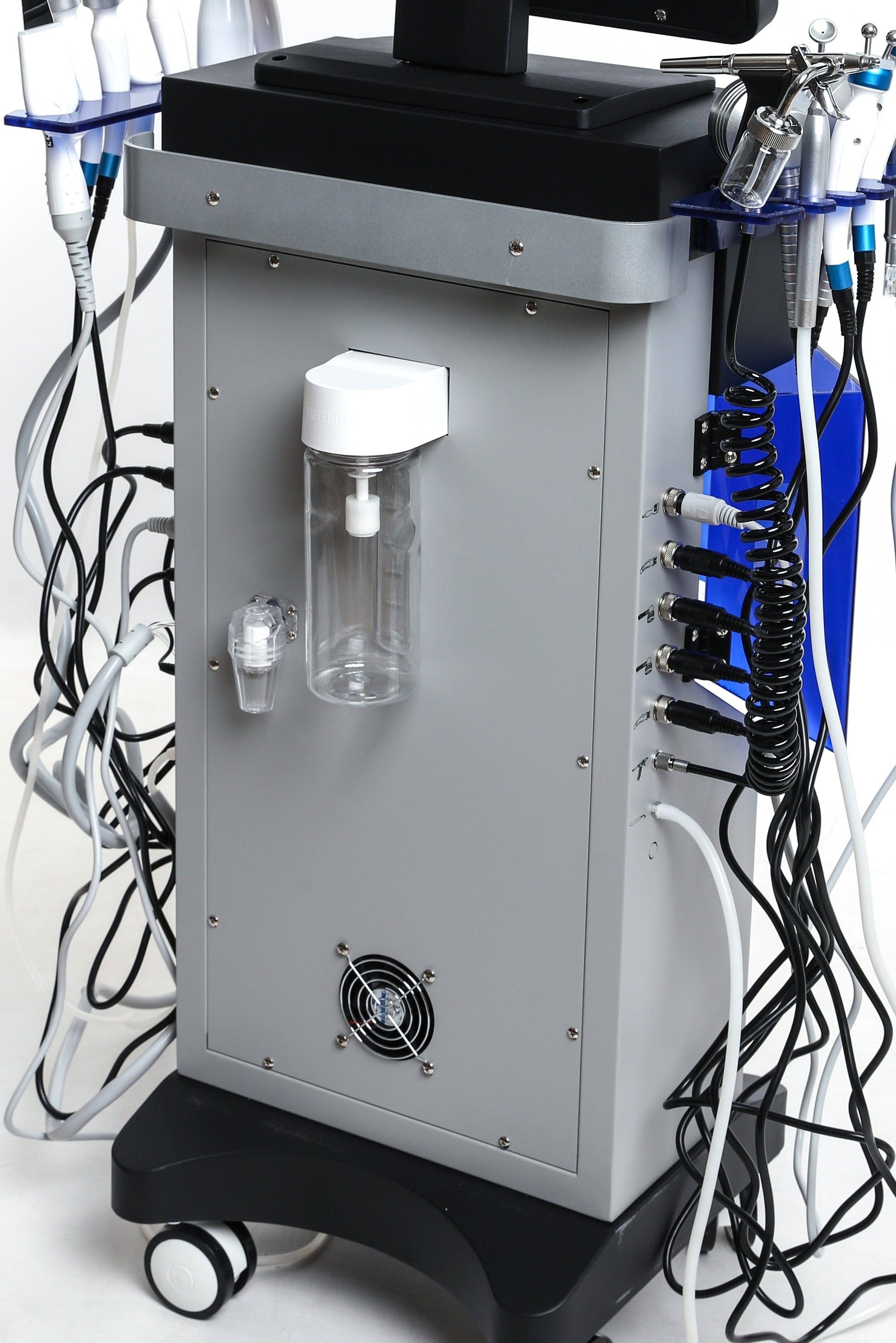 Back view of Hydra Smart Beauty facial machine showing fluid containers, power ports, and cable connections